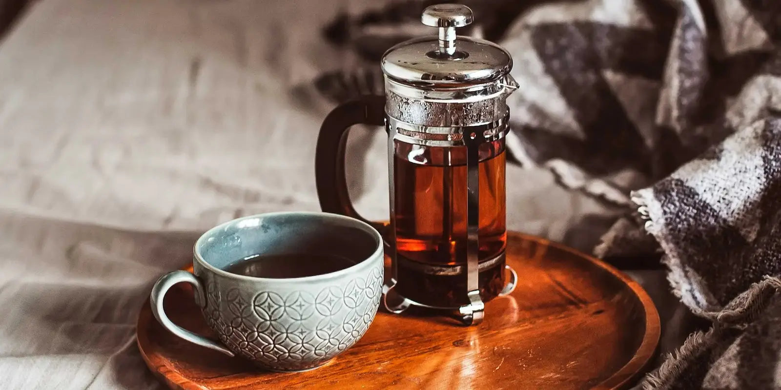 Prensa francesa junto a taza de café o té